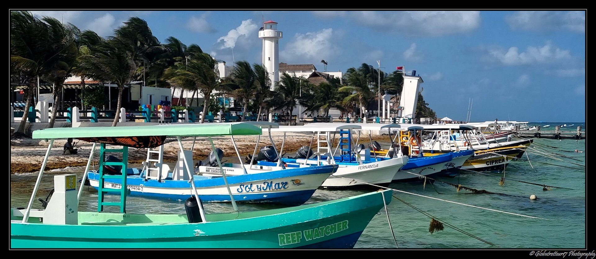 Barcas junto al faro y el frente marítimo de Puerto Morelos