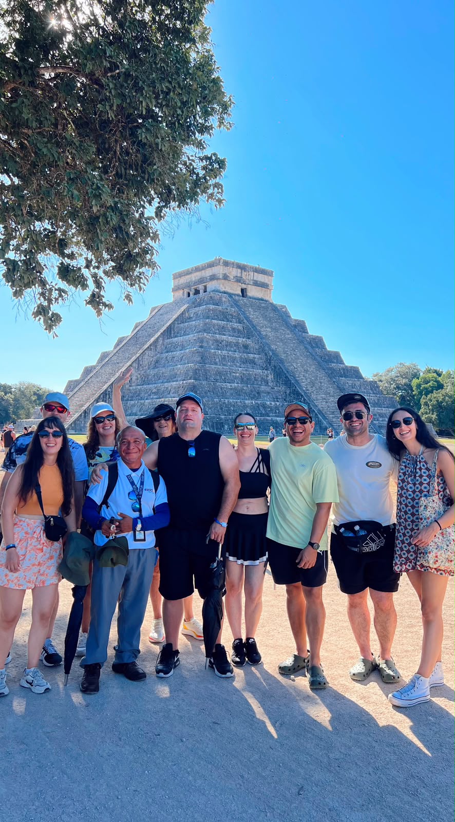Grupo reducido de viajeros con su guía frente a la pirámide de Kukulkán, en Chichén Itzá
