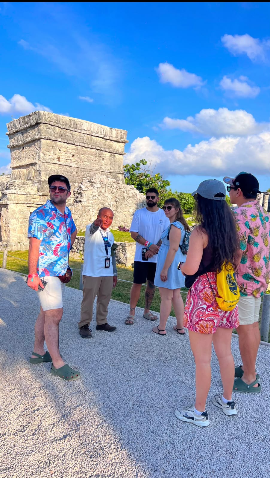 Grupo de viajeros escuchando a su guía en una zona arqueológica de la Riviera Maya