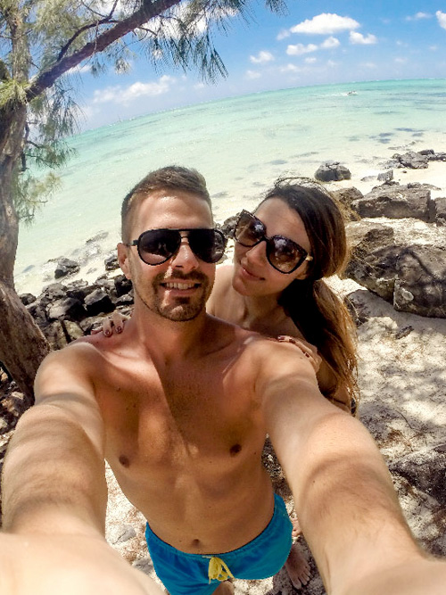 Pareja de viajeros haciéndose una foto en una cala del Caribe mexicano