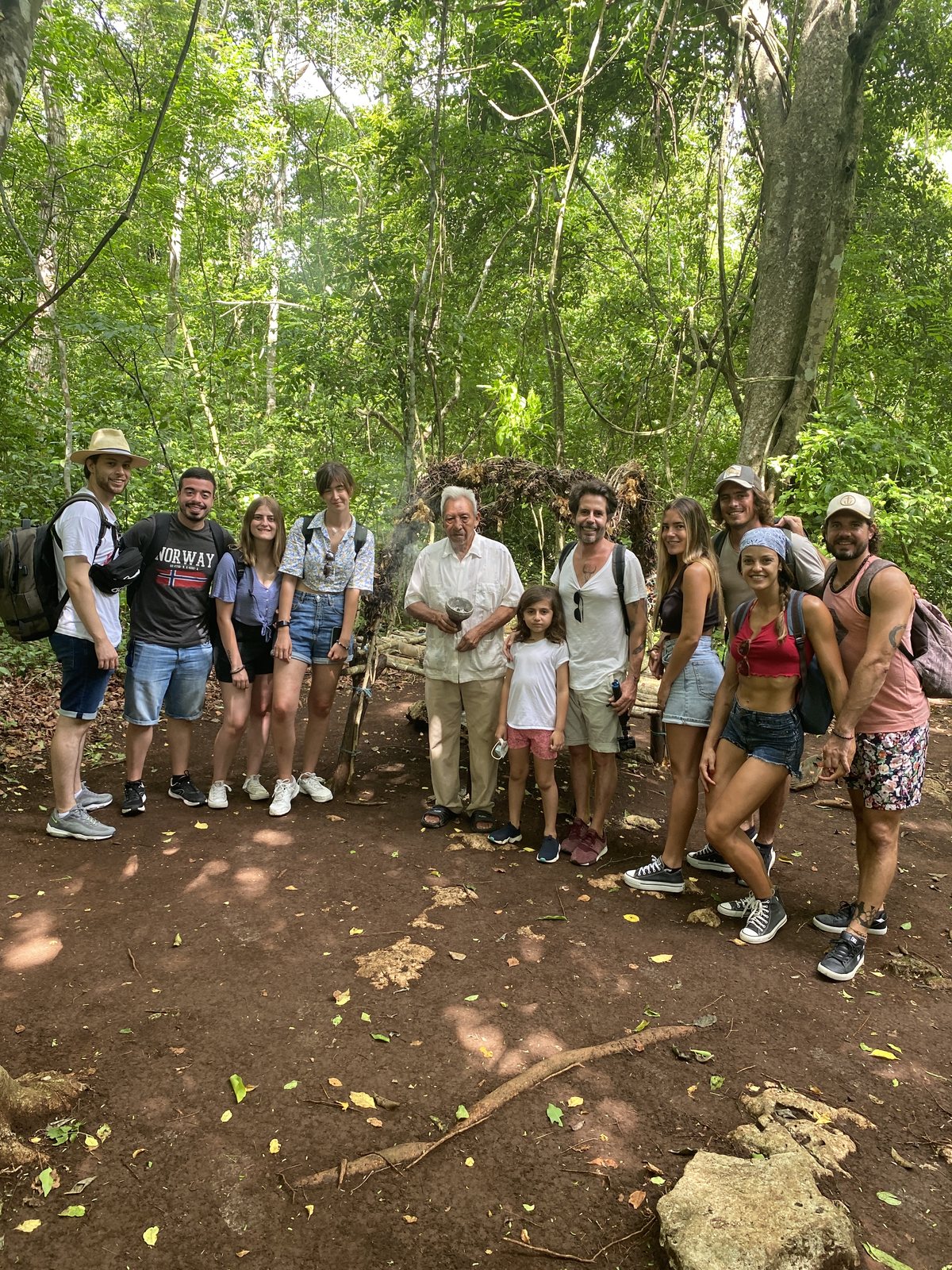 Grupo de viajeros de Exotik entre las estructuras y la selva de Cobá